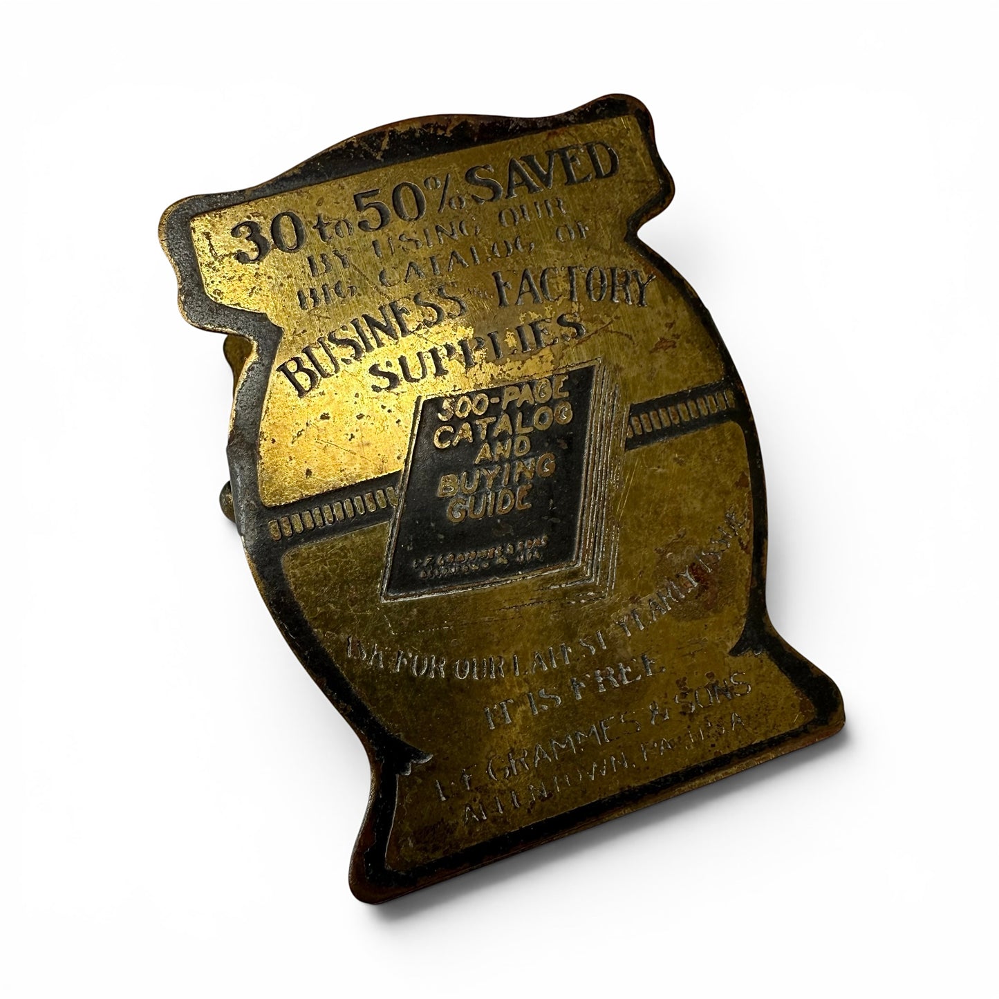1920s Brass Advertising Paper Clip Decorative metal object with text and a smaller rectangle on a white background