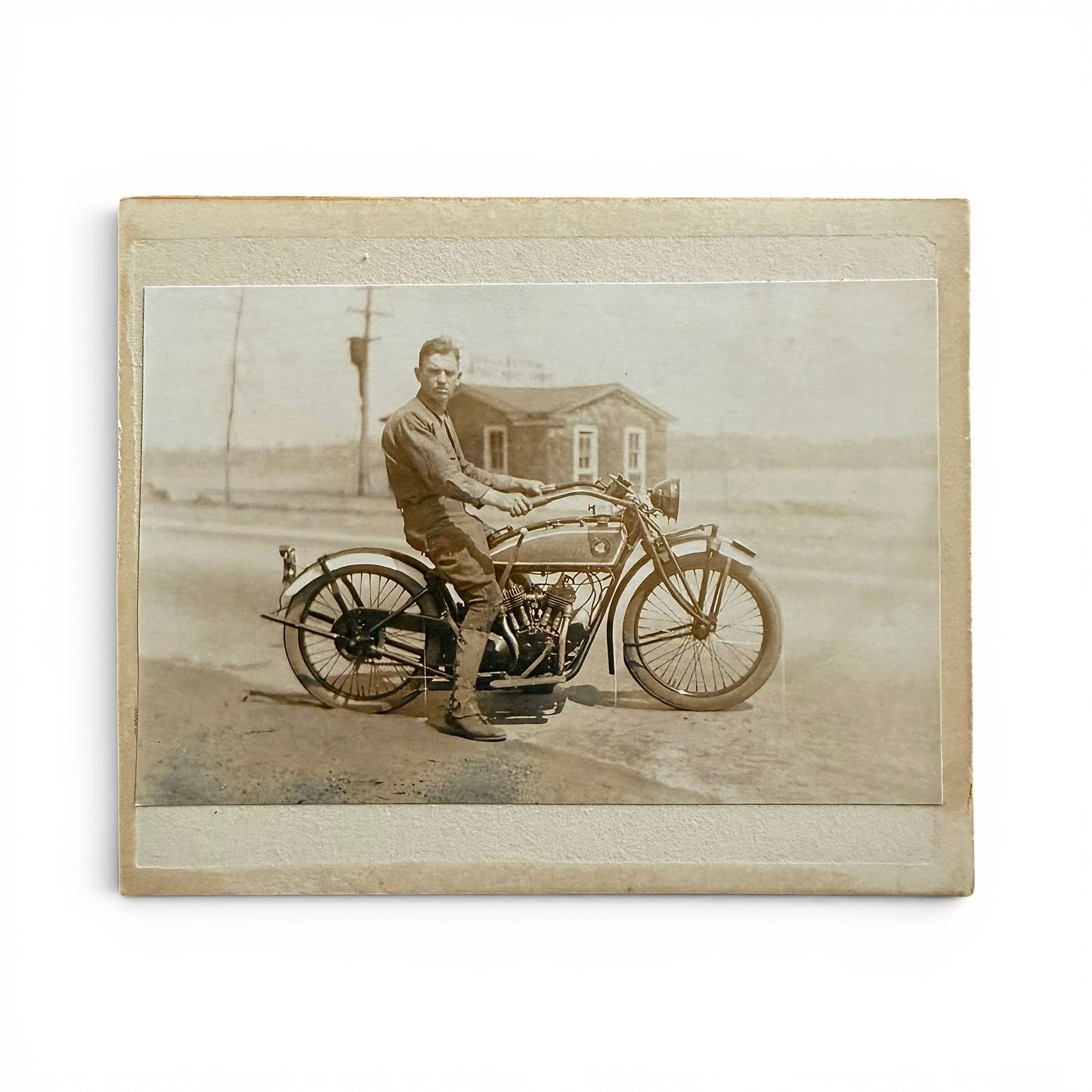 1920s Indian 101 Scout Motorcycle - Cabinet Card of a man sitting on his indian scout 101 motorcycle in a rural setting.