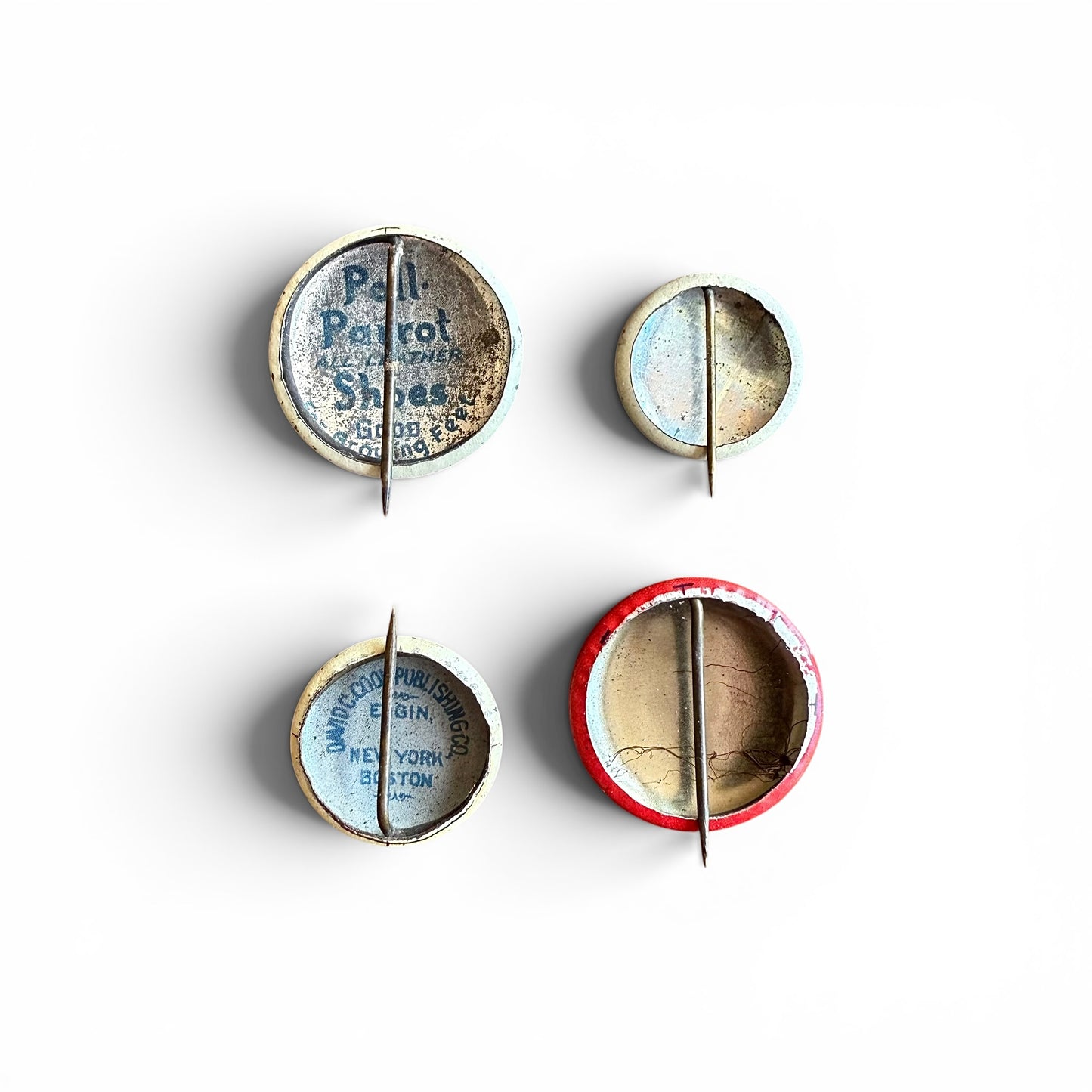 1930-1940s Pinbacks Set of four vintage buttons with different designs on a white background