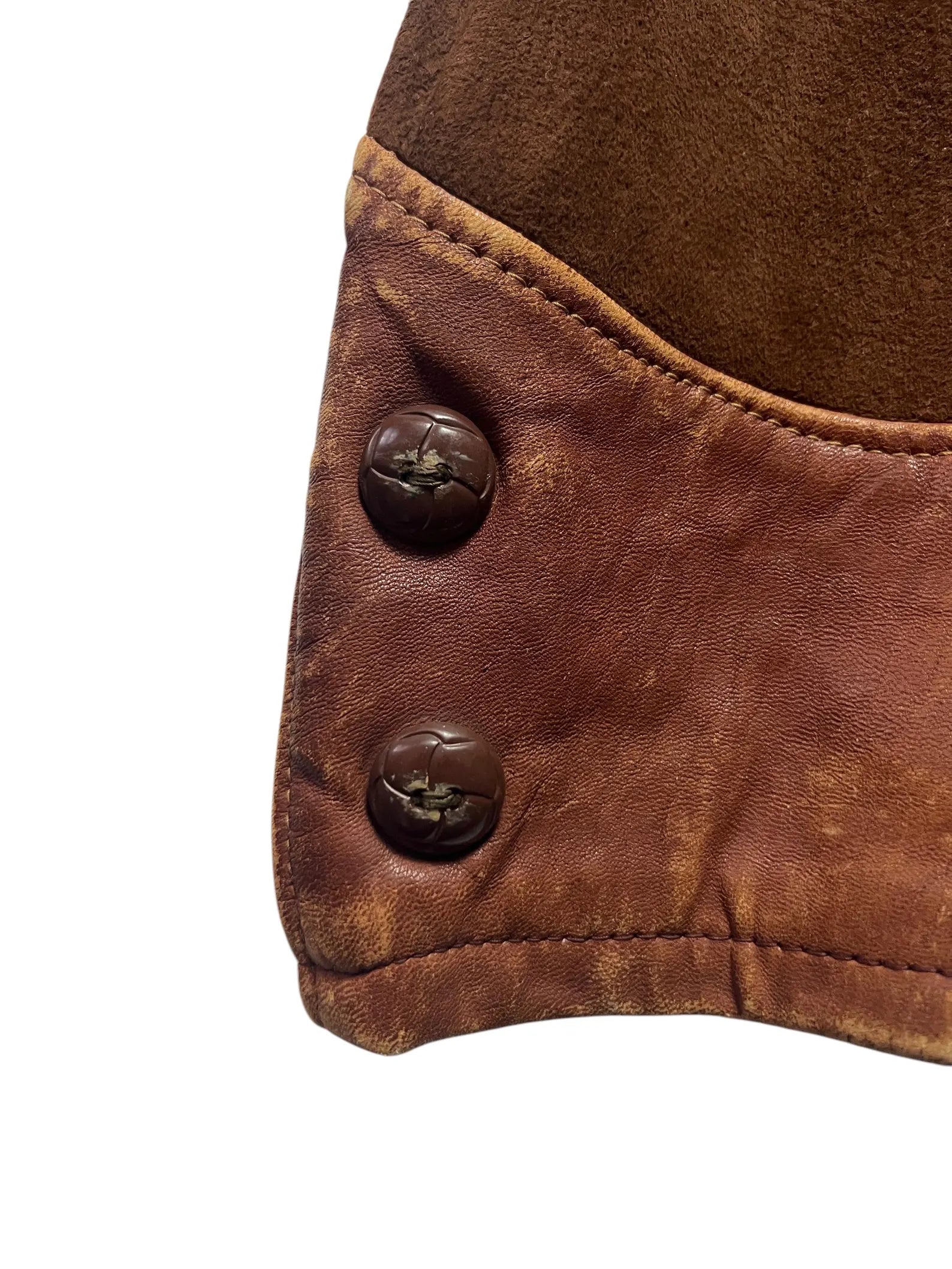 1930/1940s Cross Country Togs 2-Tone Half Belt Back Leather Jacket Close-up of a brown leather garment with two buttons on a white background