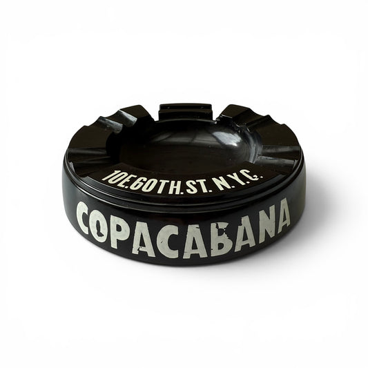 1950s Copacabana Bakelite Ashtray Black ashtray with 'Copacabana' and address text on a white background