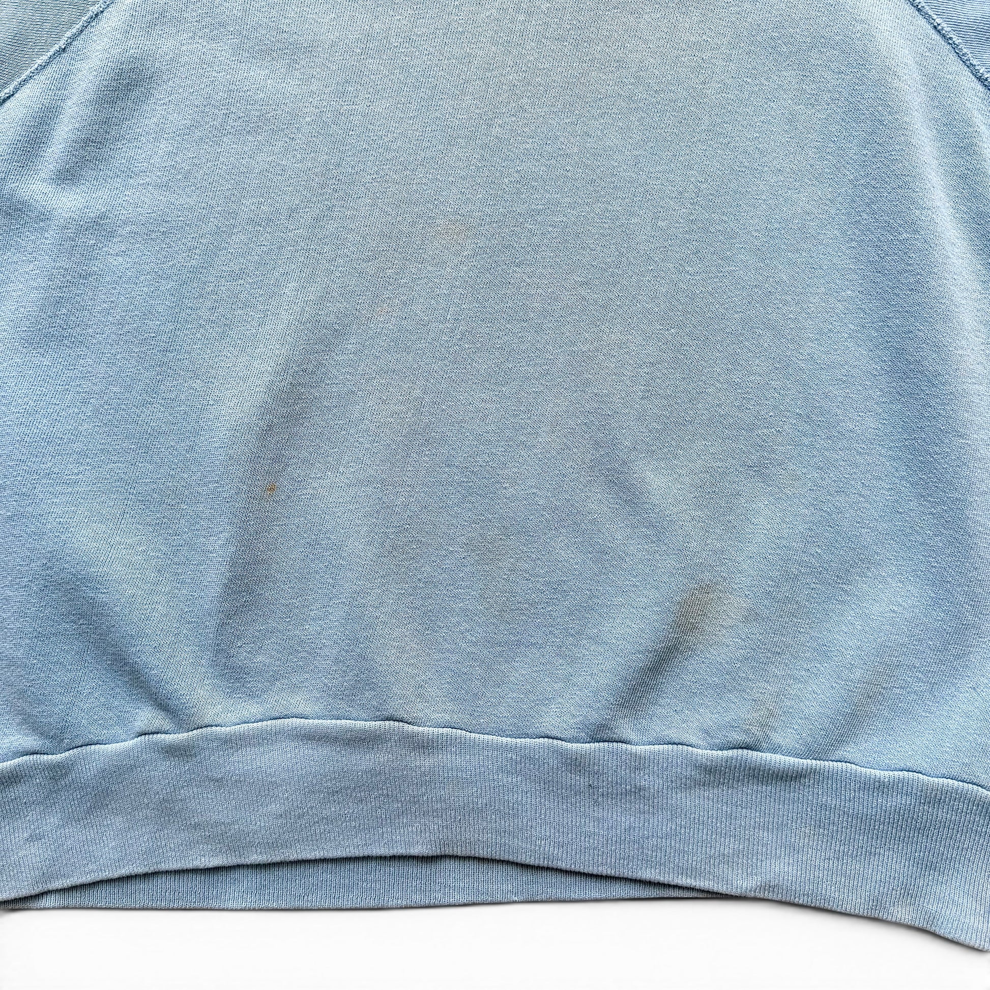 1960s Indian Motorcycles Short Sleeve Sweatshirt Close-up of a blue fabric surface with visible stains.