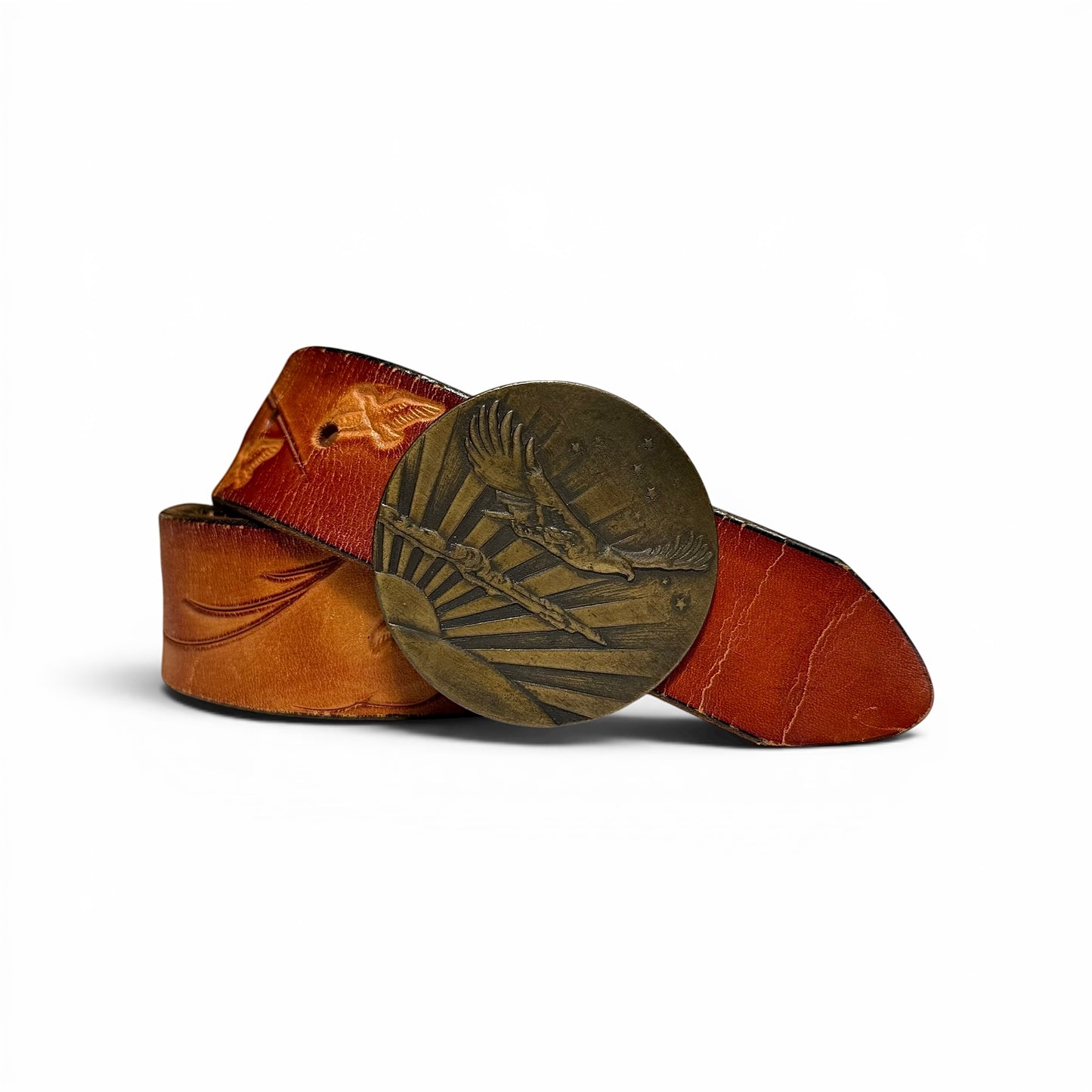 1970s Brass Eagle In Sunburst Tooled Leather Belt Brown leather belt with a decorative metal buckle on a white background