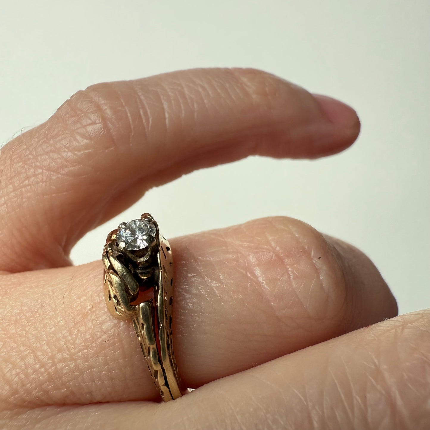 close-up Antique European Cut .25ct Diamond Bypass 14k Ring on hand 