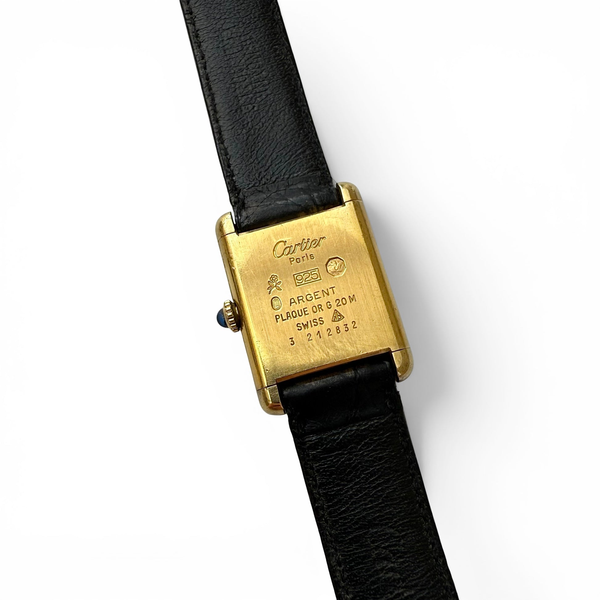 Late 1970s Must De Cartier Manual Wind Tank Watch Cartier watch with gold case and black leather strap on a white background