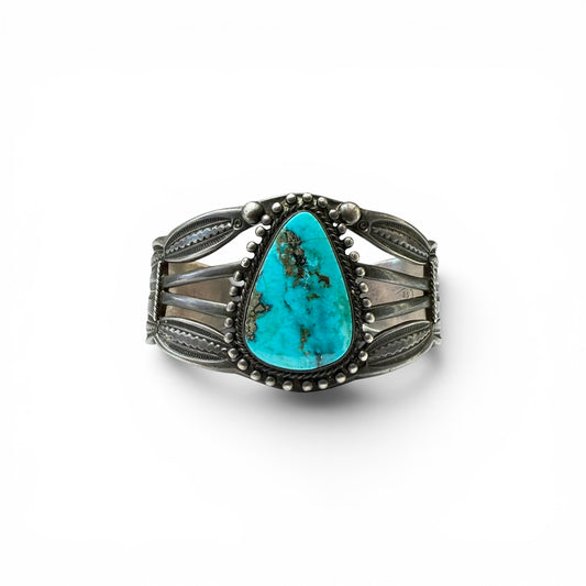 Vintage Sterling Silver & Turquoise Diné (Navajo) Bracelet Turquoise stone bracelet with silver detailing on a white background