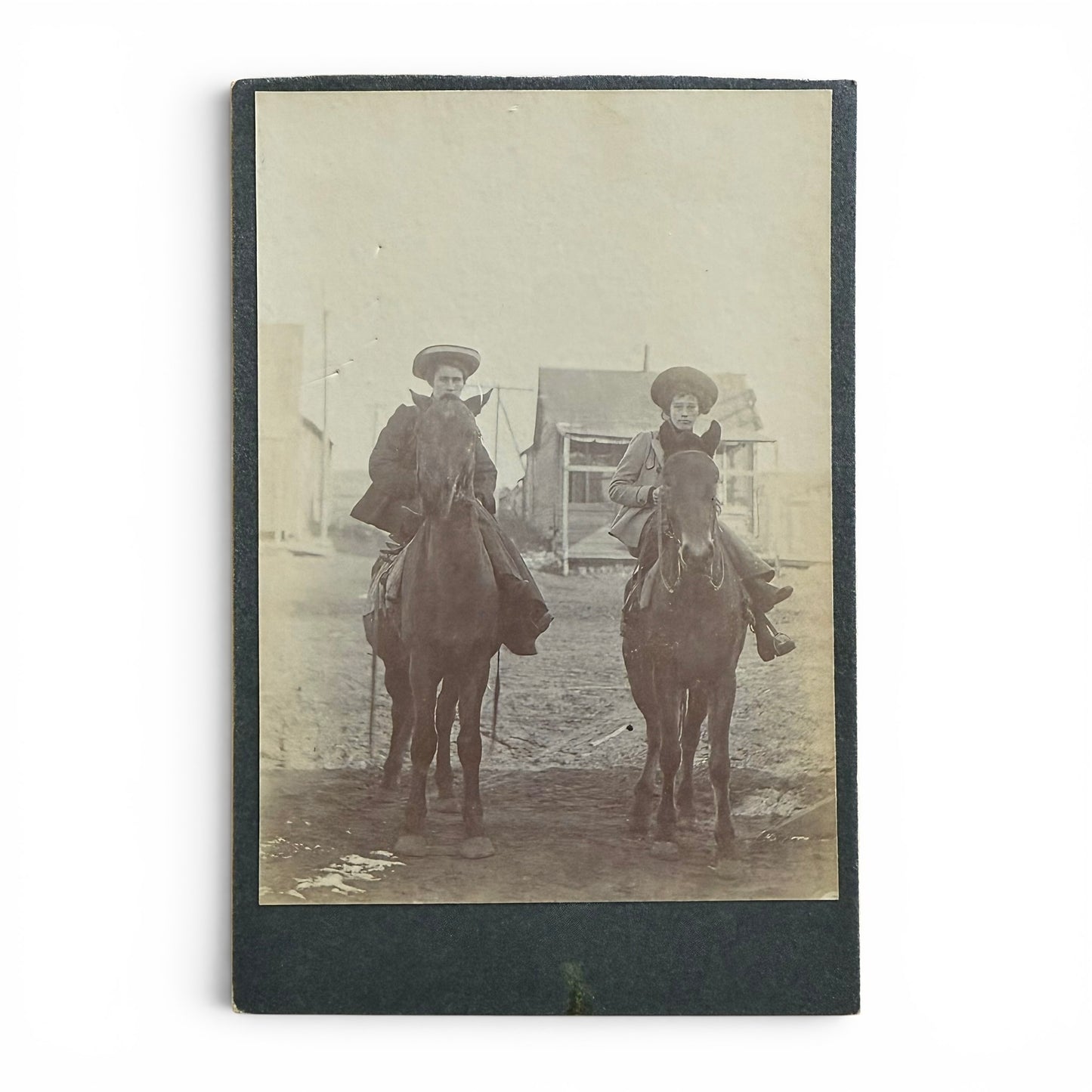 Women Of The Old West- Cabinet Card Vintage photograph of two women on horseback with a building in the background